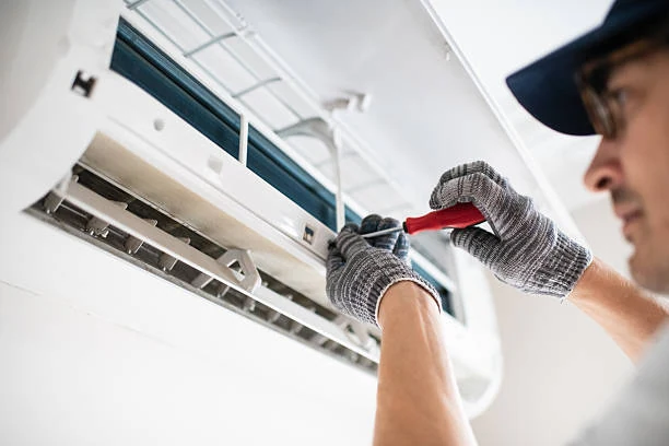 Technician securing the components of a wall-mounted air conditioner